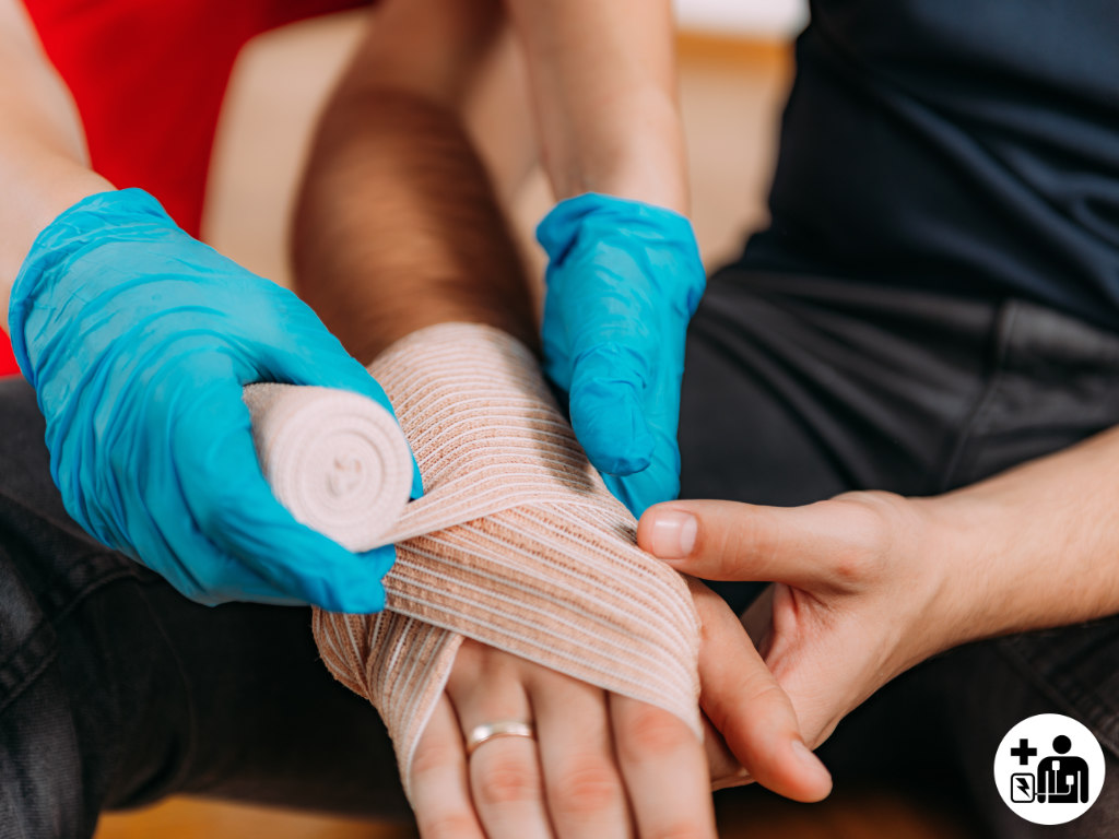 Arm being bandaged first aid gloves in care setting being worn by first aider